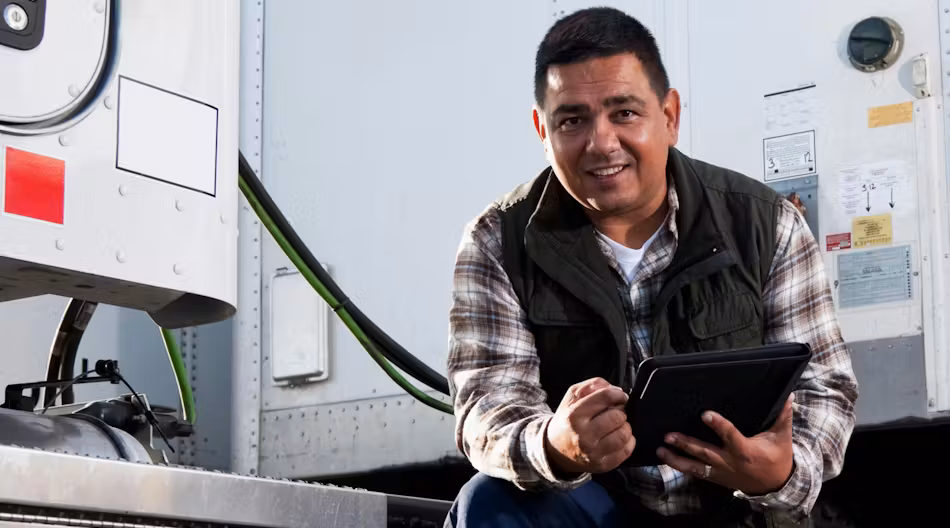 A truck driver completing an inspection